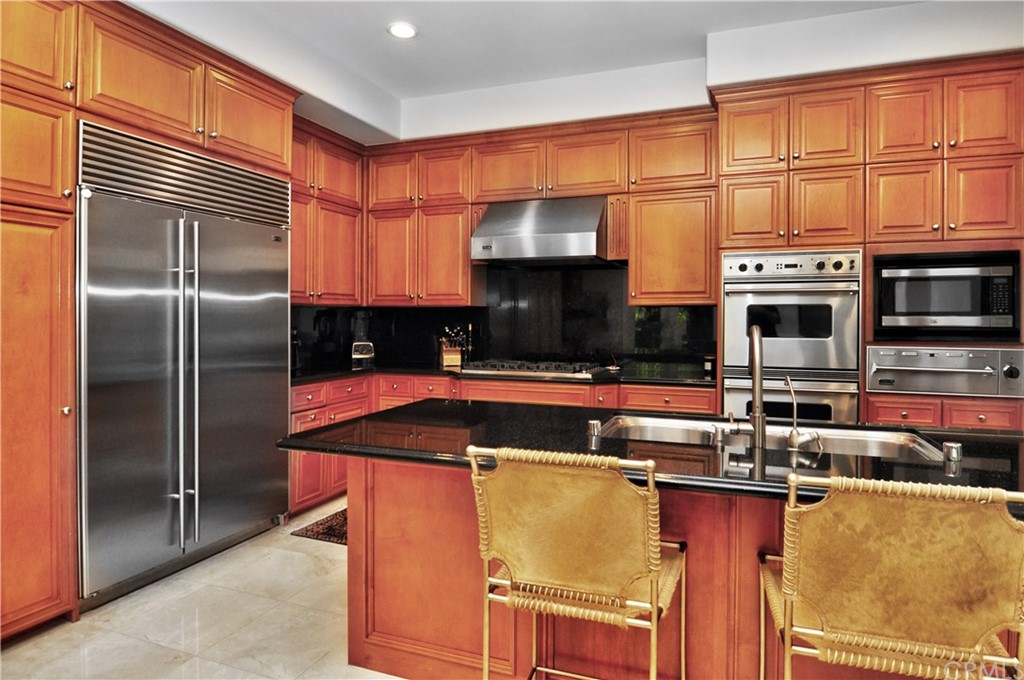 21 Catania Newport Coast, CA 92657 - Photo 12 of 31 a kitchen with stainless steel appliances granite countertop a refrigerator a stove and a sink with wooden floors