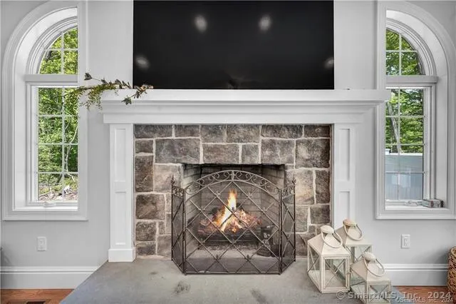 a living room with a fireplace and a large window