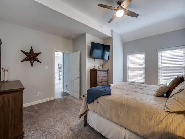a spacious bedroom with a bed and a chandelier