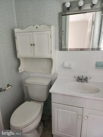a white toilet sitting next to a bath tub