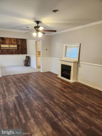 a view of an empty room with a fireplace and a window
