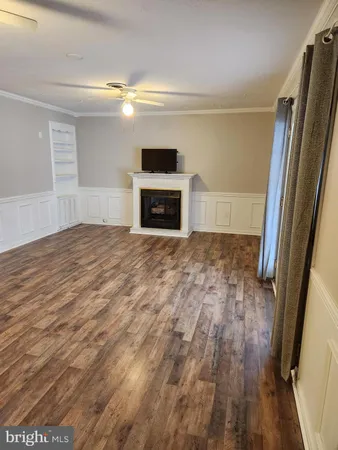 a view of empty room with wooden floor and fireplace
