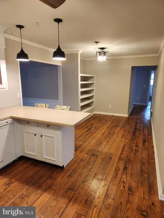 a kitchen with wooden floors and white cabinets