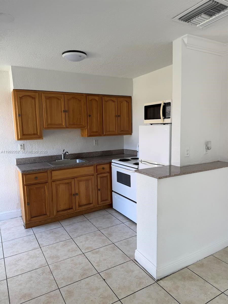 3901 Southwest 109th Avenue, Unit 8 Miami, FL 33165 - Photo 6 of 7 a kitchen with stainless steel appliances granite countertop a stove a sink and a refrigerator