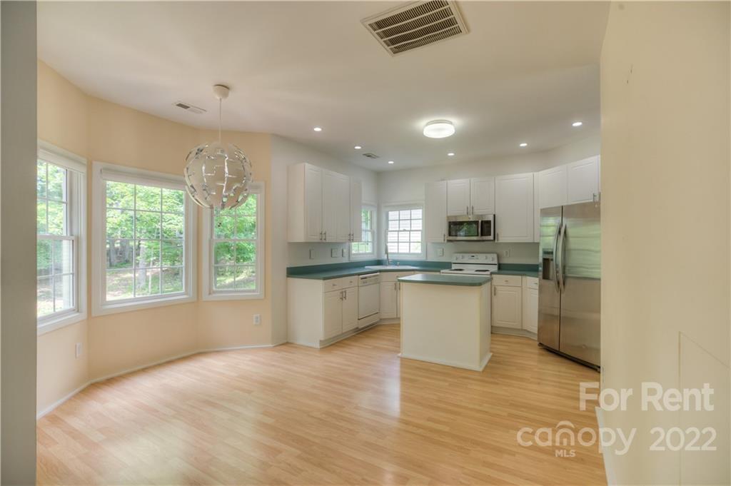 2857 Windsor Chase Drive Matthews, NC 28105 - Photo 13 of 46 a kitchen with a refrigerator and white cabinets