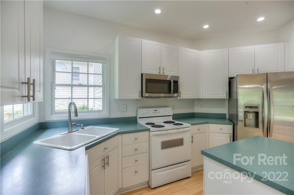 2857 Windsor Chase Drive Matthews, NC 28105 - Photo 19 of 46 a kitchen that has a sink stainless steel appliances a window and a counter top space
