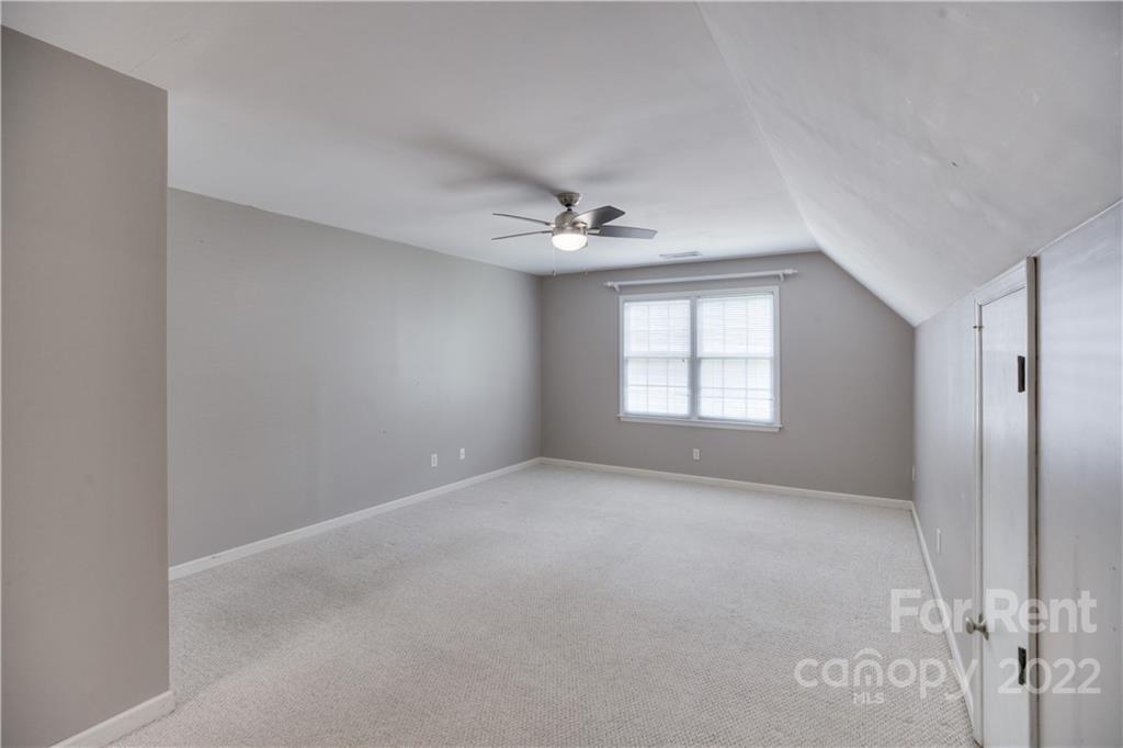 2857 Windsor Chase Drive Matthews, NC 28105 - Photo 26 of 46 an empty room with windows and ceiling fan
