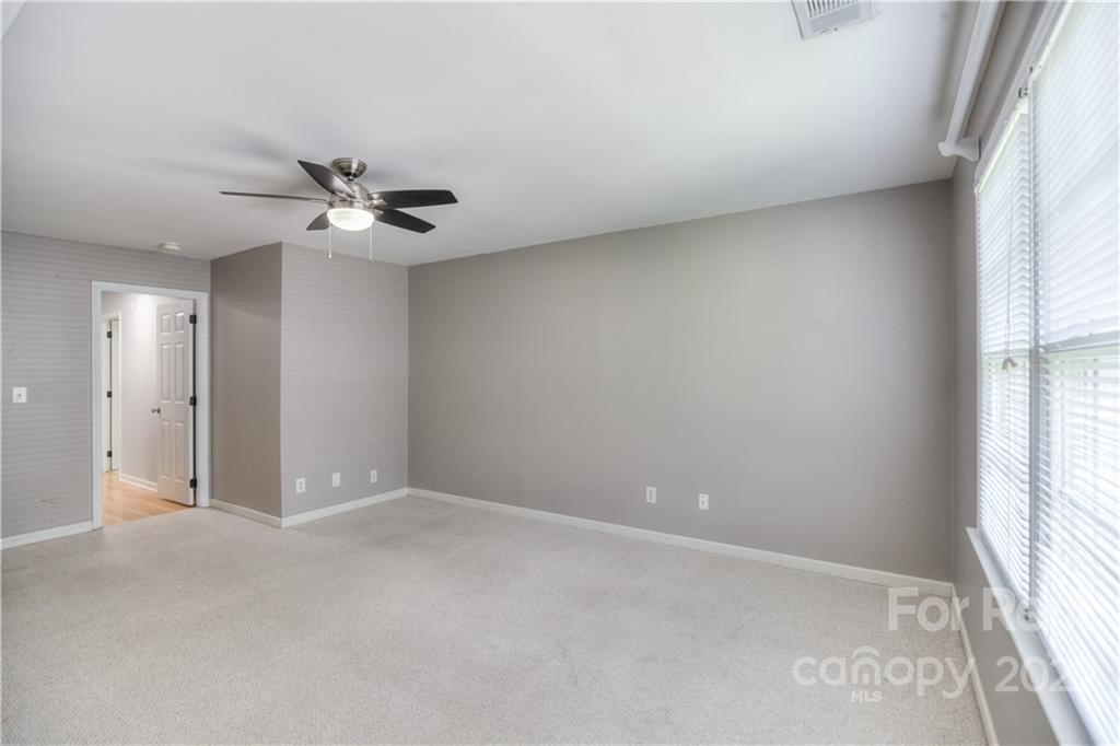 2857 Windsor Chase Drive Matthews, NC 28105 - Photo 27 of 46 an empty room with windows and ceiling fan