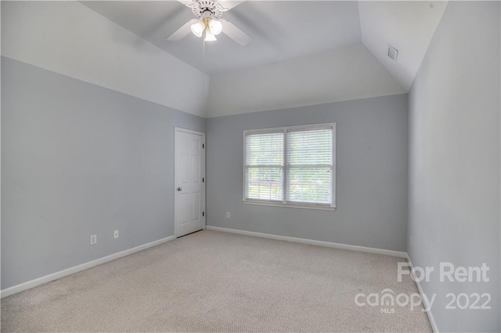 2857 Windsor Chase Drive Matthews, NC 28105 - Photo 31 of 46 an empty room with a chandelier fan and windows