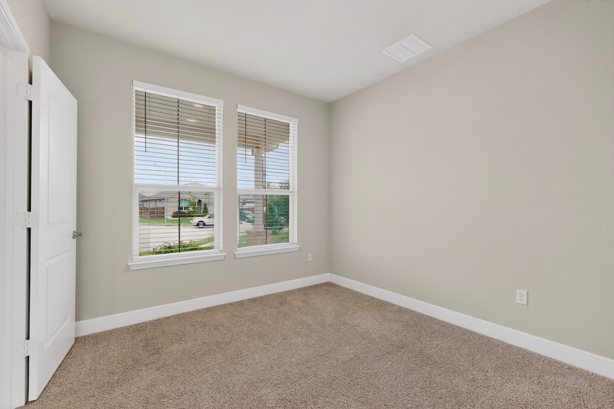 16809 Guido Cove Pflugerville, TX 78660 - Photo 32 of 40 Neutral-toned room with plush carpet flooring, two windows featuring white blinds, and white trim
