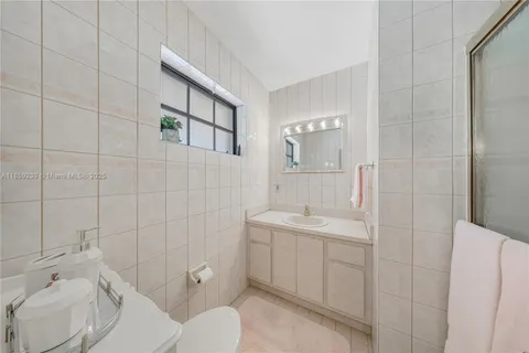 a spacious bathroom with a granite countertop sink mirror and a bathtub