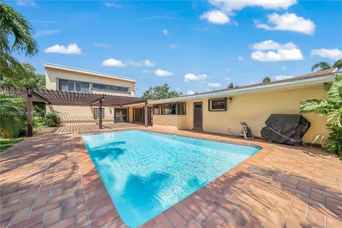 a view of a big house with a big yard and palm trees