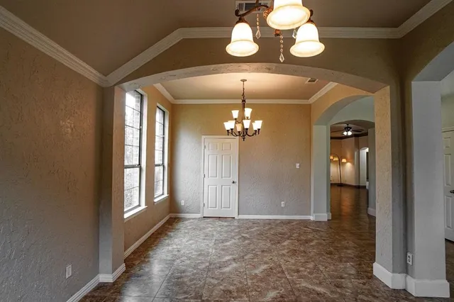 a view of a hallway with wooden floor and chandelier