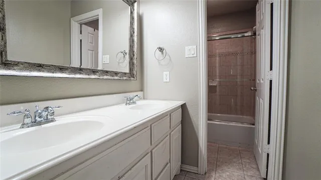 an empty room with chandelier fan and windows