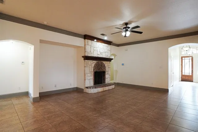 a view of an empty room with window and fireplace