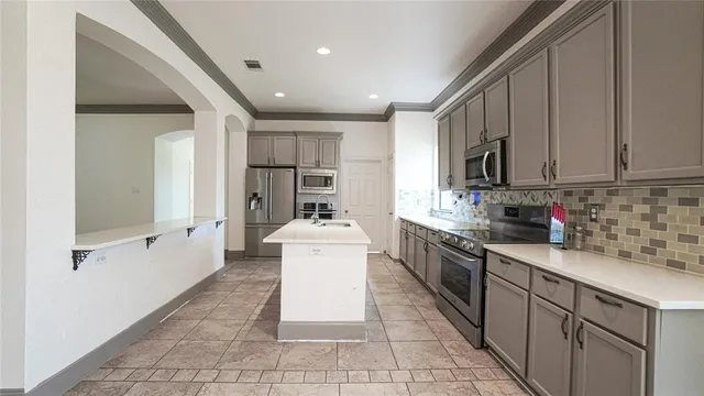 a kitchen with stainless steel appliances kitchen island granite countertop a sink and cabinets