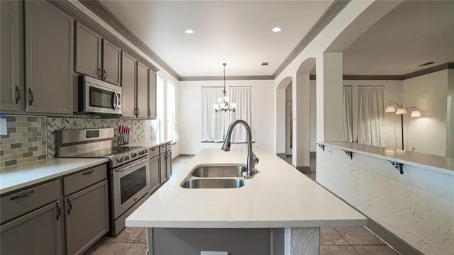 a kitchen with stainless steel appliances granite countertop a sink a stove and a refrigerator