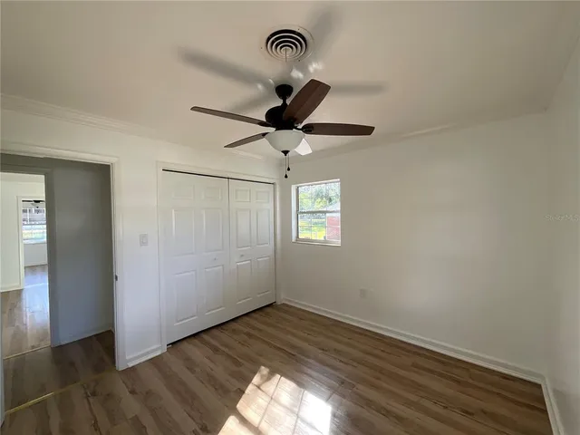 a view of empty room with wooden floor
