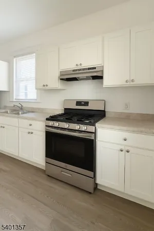 a kitchen with granite countertop white cabinets and stainless steel appliances