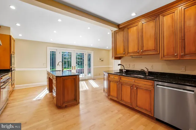 a kitchen with stainless steel appliances granite countertop a refrigerator and a stove top oven