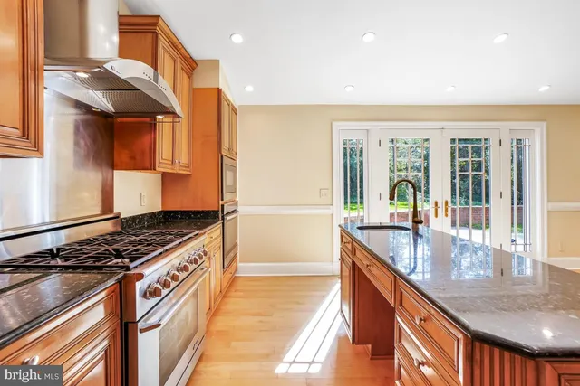 an empty room with wooden floor fireplace and windows