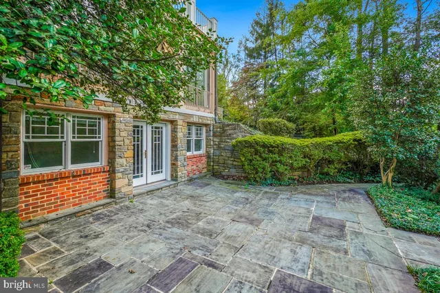 a view of a house with brick walls and a yard with plants