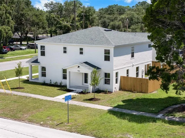a aerial view of a house next to a big yard and large trees