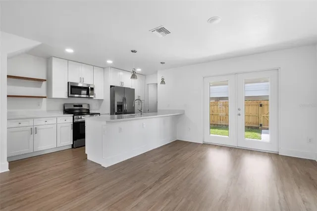 a kitchen with wooden floors and white appliances