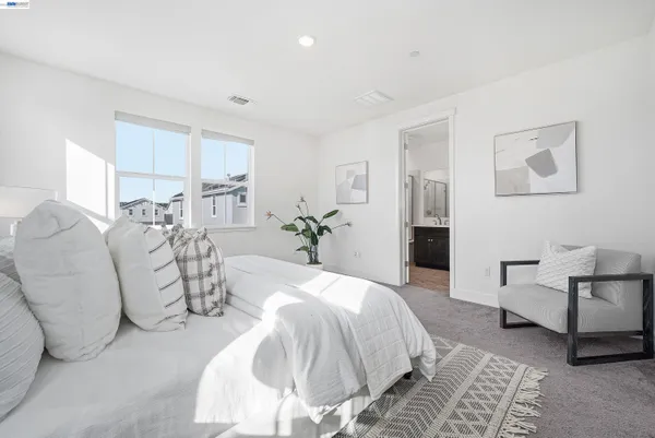 a bedroom with a large bed and a chandelier