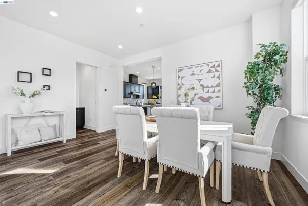 a living room with couches and a dining table with kitchen view
