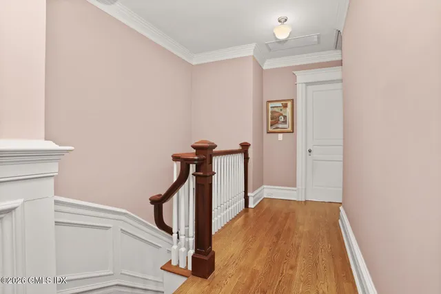 a view of a hallway with wooden floor and staircase