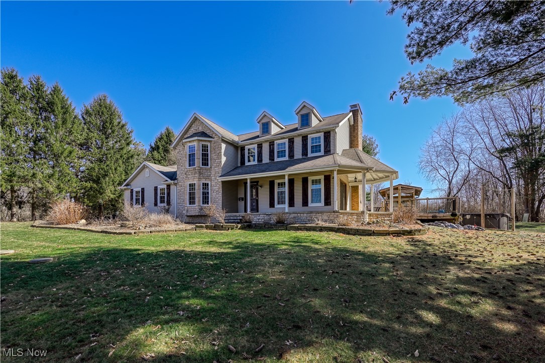 2061 Portage Line Road Mogadore, OH 44260 - Photo 6 of 48 View of front of property with a porch, stone siding, a chimney, and a front lawn