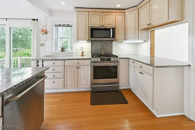 a kitchen with granite countertop a stove a sink and a microwave