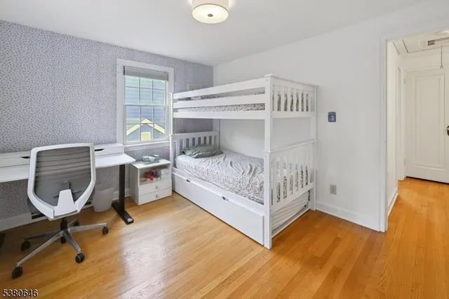 a bedroom with a bed a chair and a potted plant on the table