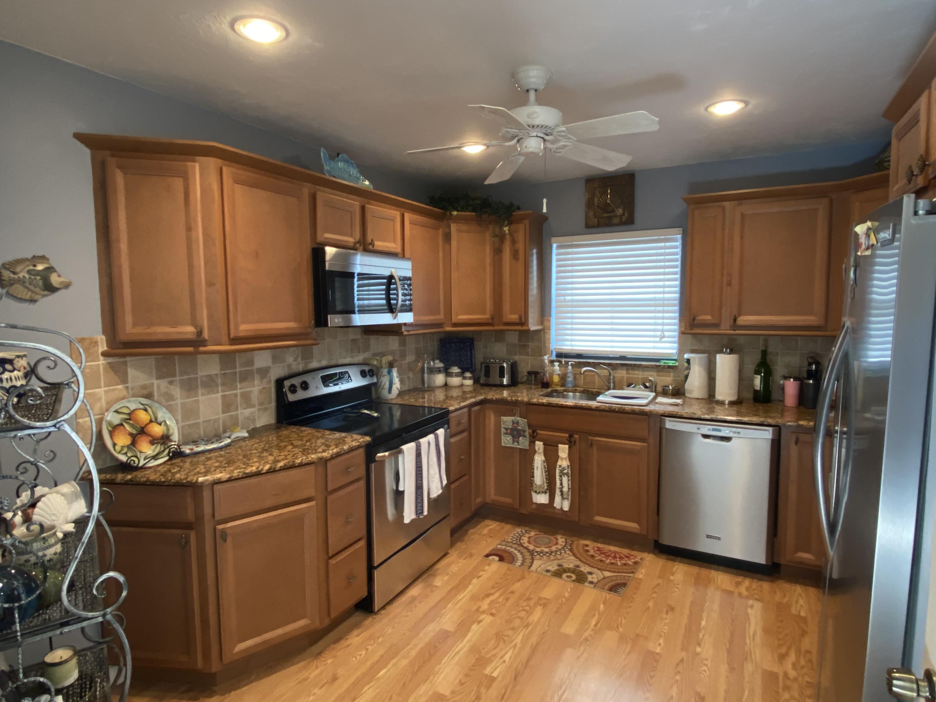 a kitchen with stainless steel appliances granite countertop a stove sink microwave and refrigerator