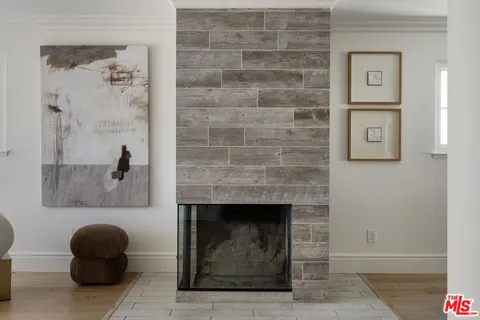 a room with a fireplace and a potted plant on brick wall
