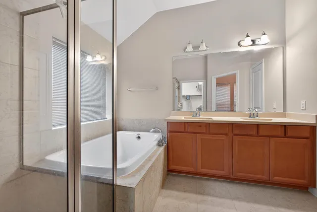 a bathroom with a tub sink shower and mirror