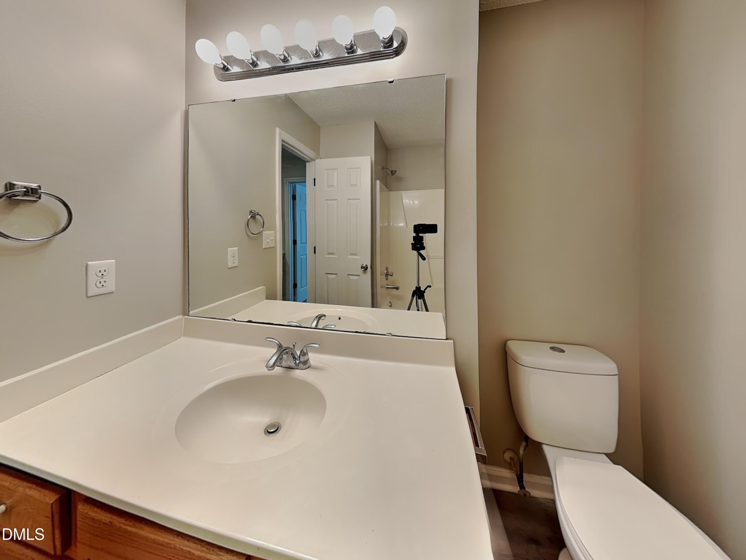 4409 Woodlawn Drive Raleigh, NC 27616 - Photo 14 of 15 a bathroom with a toilet a sink and mirror