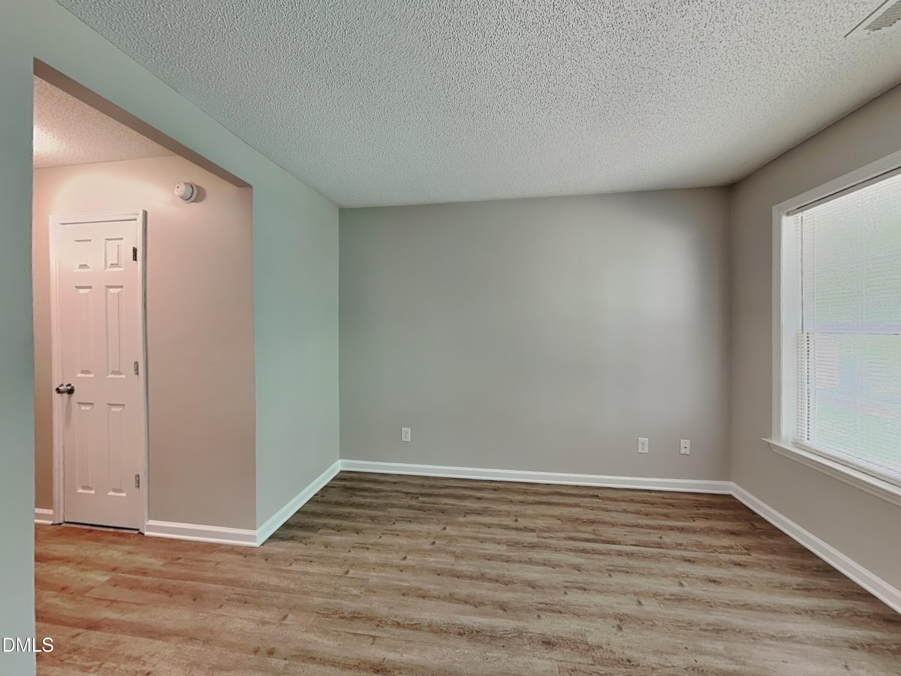 4409 Woodlawn Drive Raleigh, NC 27616 - Photo 3 of 15 a view of an empty room with wooden floor and a window