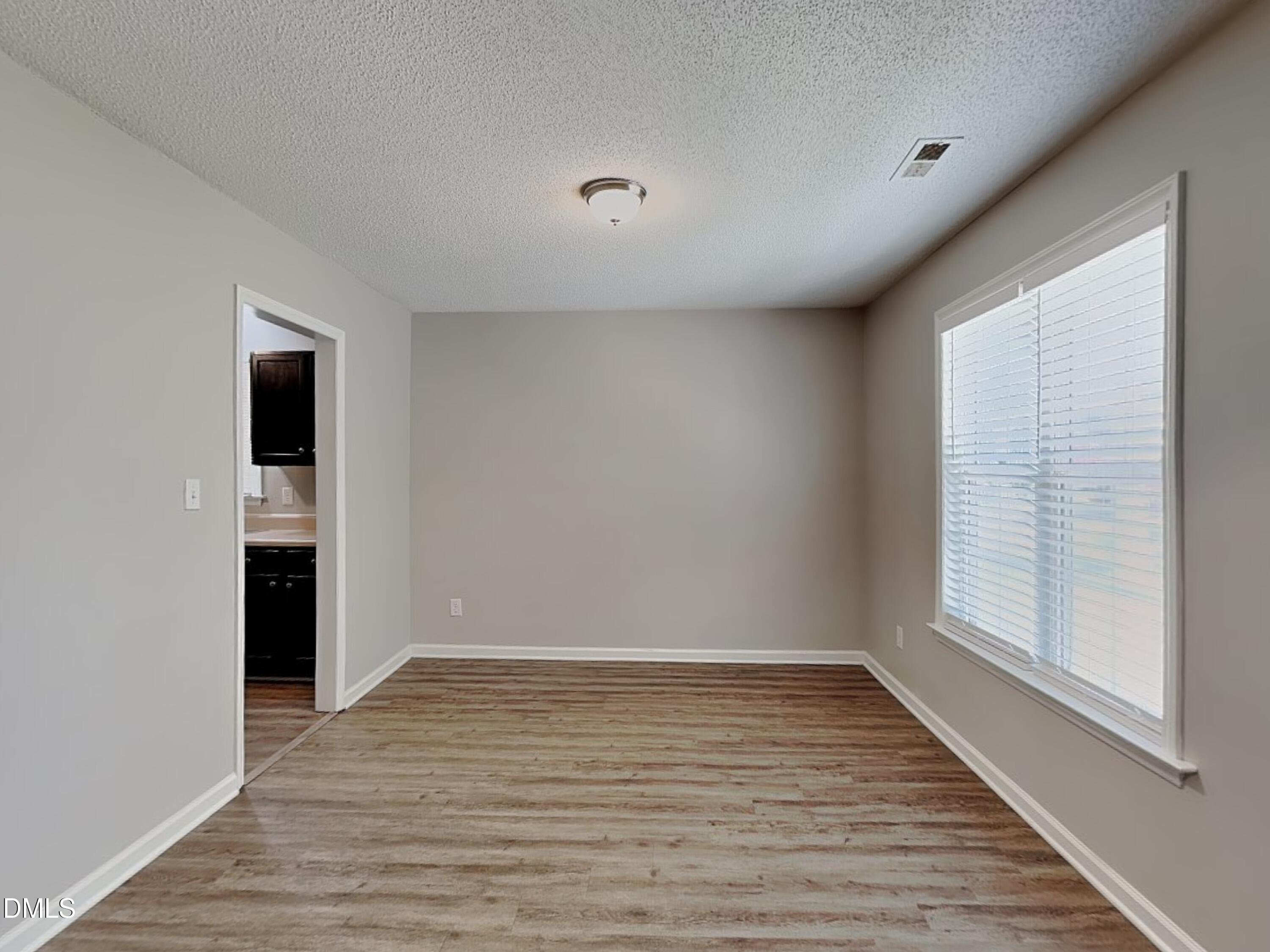4409 Woodlawn Drive Raleigh, NC 27616 - Photo 4 of 15 wooden floor in an empty room with a window
