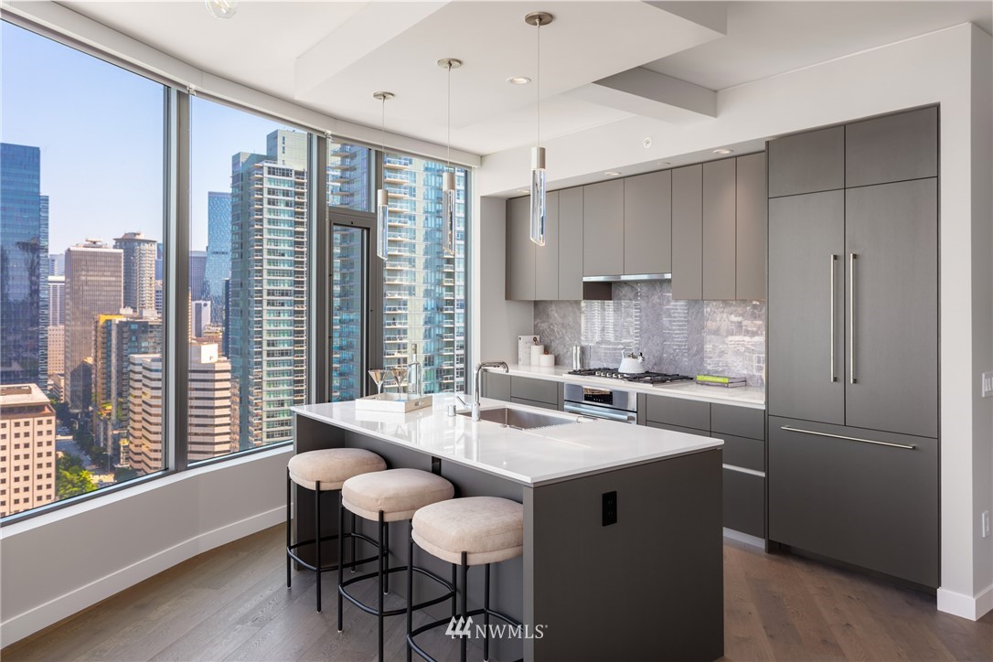 2510 6th Avenue, Unit 3502 Seattle, WA 98121 - Photo 12 of 38 a kitchen with a table chairs refrigerator and cabinets