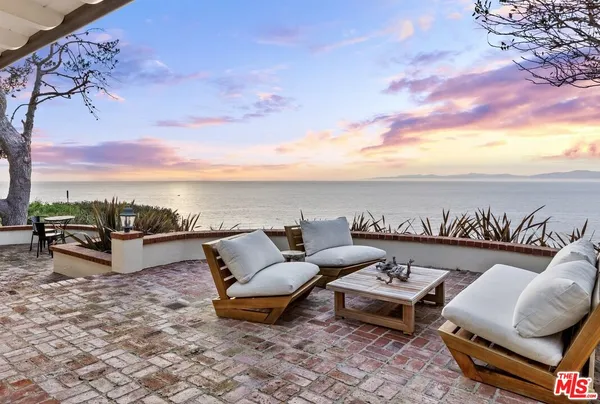 an outdoor living room with patio furniture