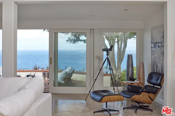 a living room with furniture and a floor to ceiling window