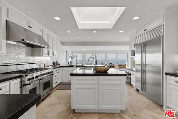 a kitchen with stainless steel appliances granite countertop a sink a stove and a refrigerator