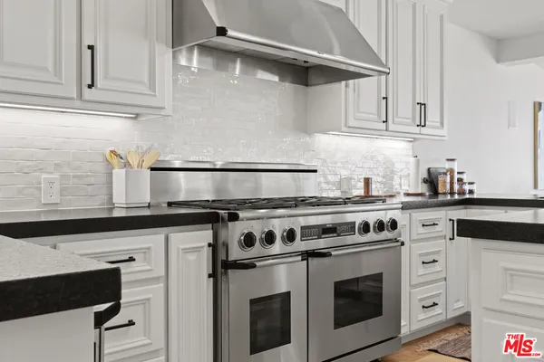 a stove top oven sitting inside of a kitchen