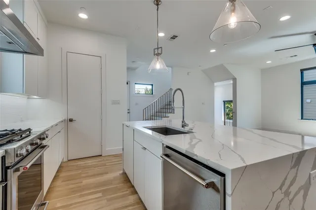 a kitchen with stainless steel appliances granite countertop a sink stove and refrigerator