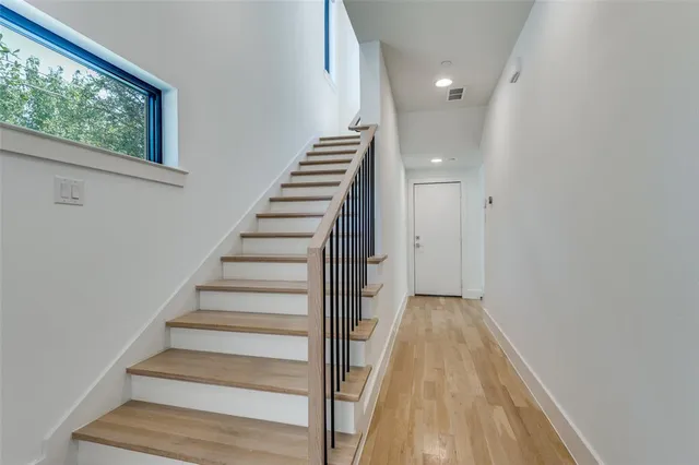 a view of a hallway with wooden floor and entryway