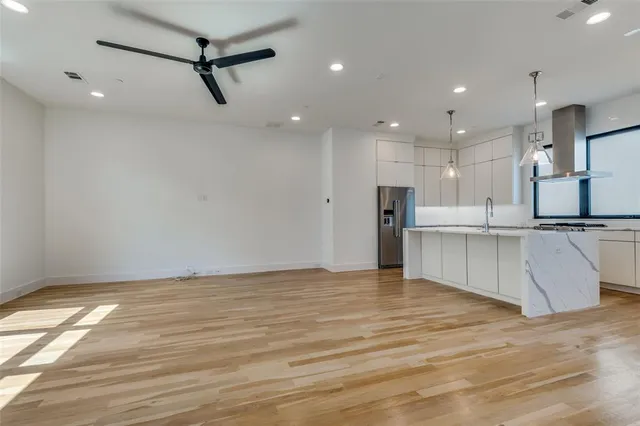 a view of kitchen with sink and refrigerator