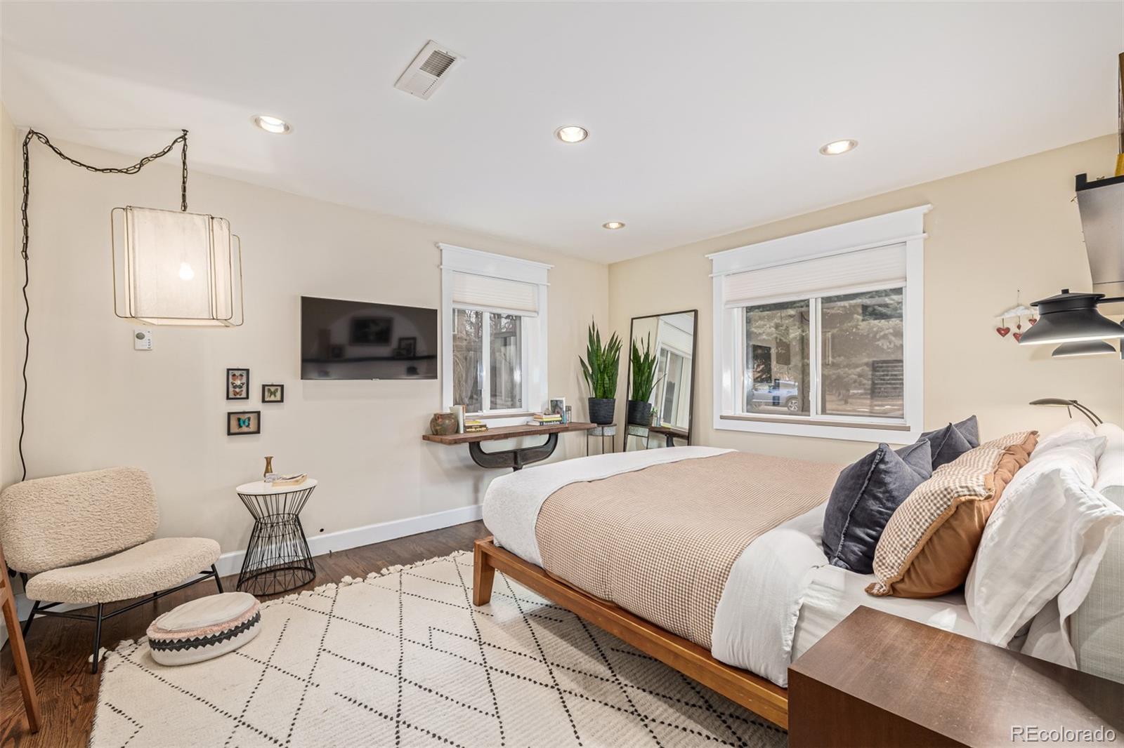 1227 Elm Street Denver, CO 80220 - Photo 15 of 44 a spacious bedroom with a bed and a flat screen tv