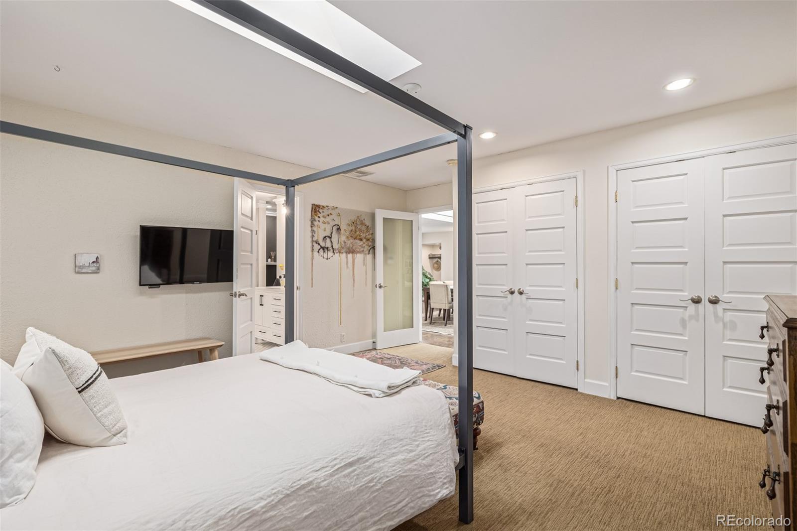 1227 Elm Street Denver, CO 80220 - Photo 20 of 44 a bedroom with a bed and a flat screen tv